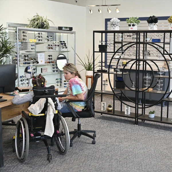 Customer consultation area showing attentive service and a wide selection of eyeglass frames.