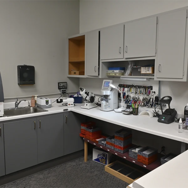 Optical lab workspace equipped with professional tools, machines, and organized supplies.